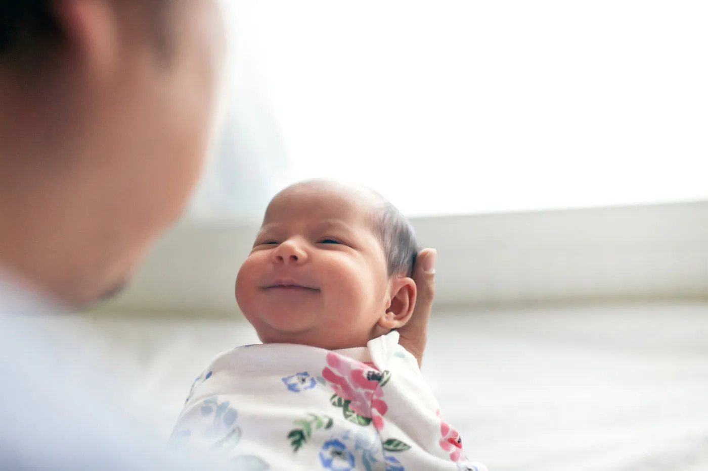 Close up of a newborn being held by parent